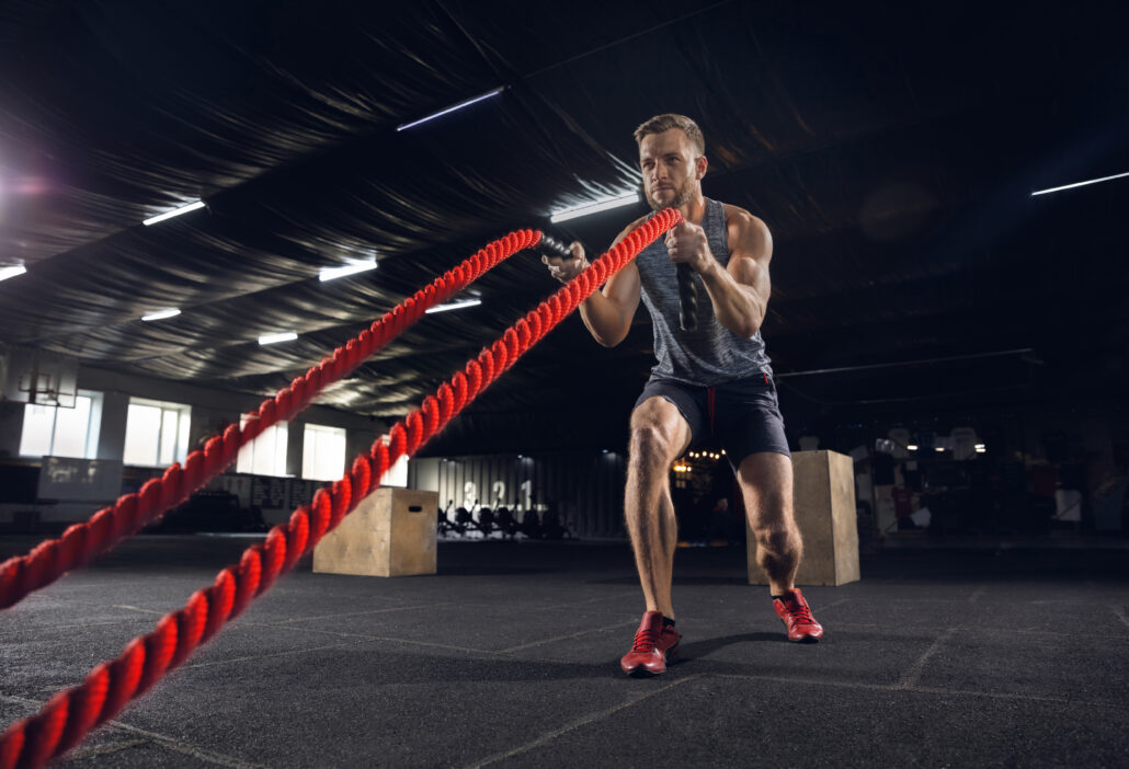 young healthy man athlete doing exercise with ropes gym single male model practicing hard training his upper body concept healthy lifestyle sport fitness bodybuilding wellbeing